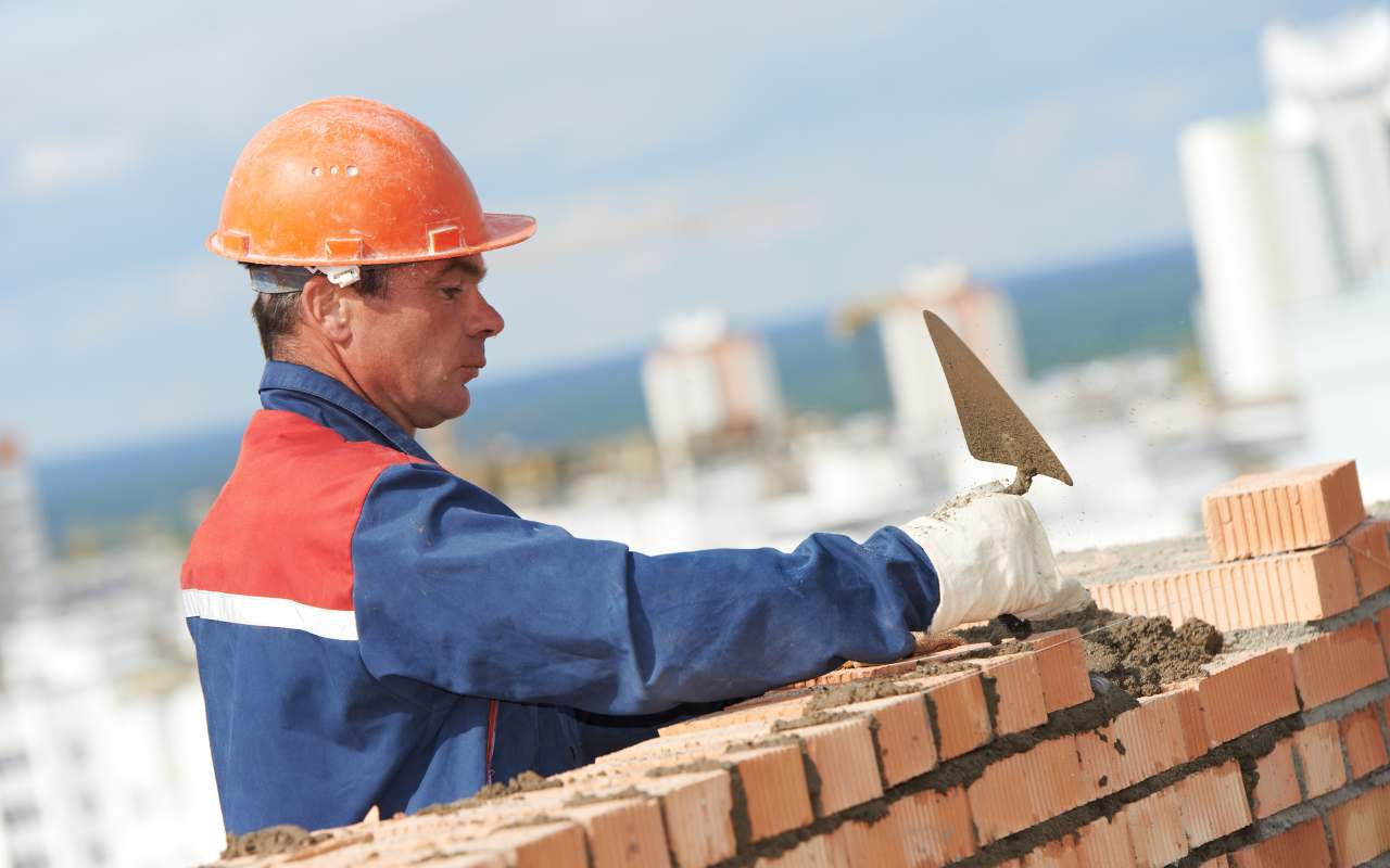 Professional mason precisely laying bricks.